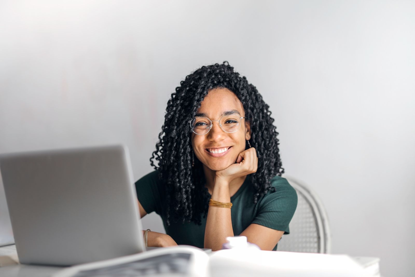 Smiling Black woman working on her laptop — WomenThrive community